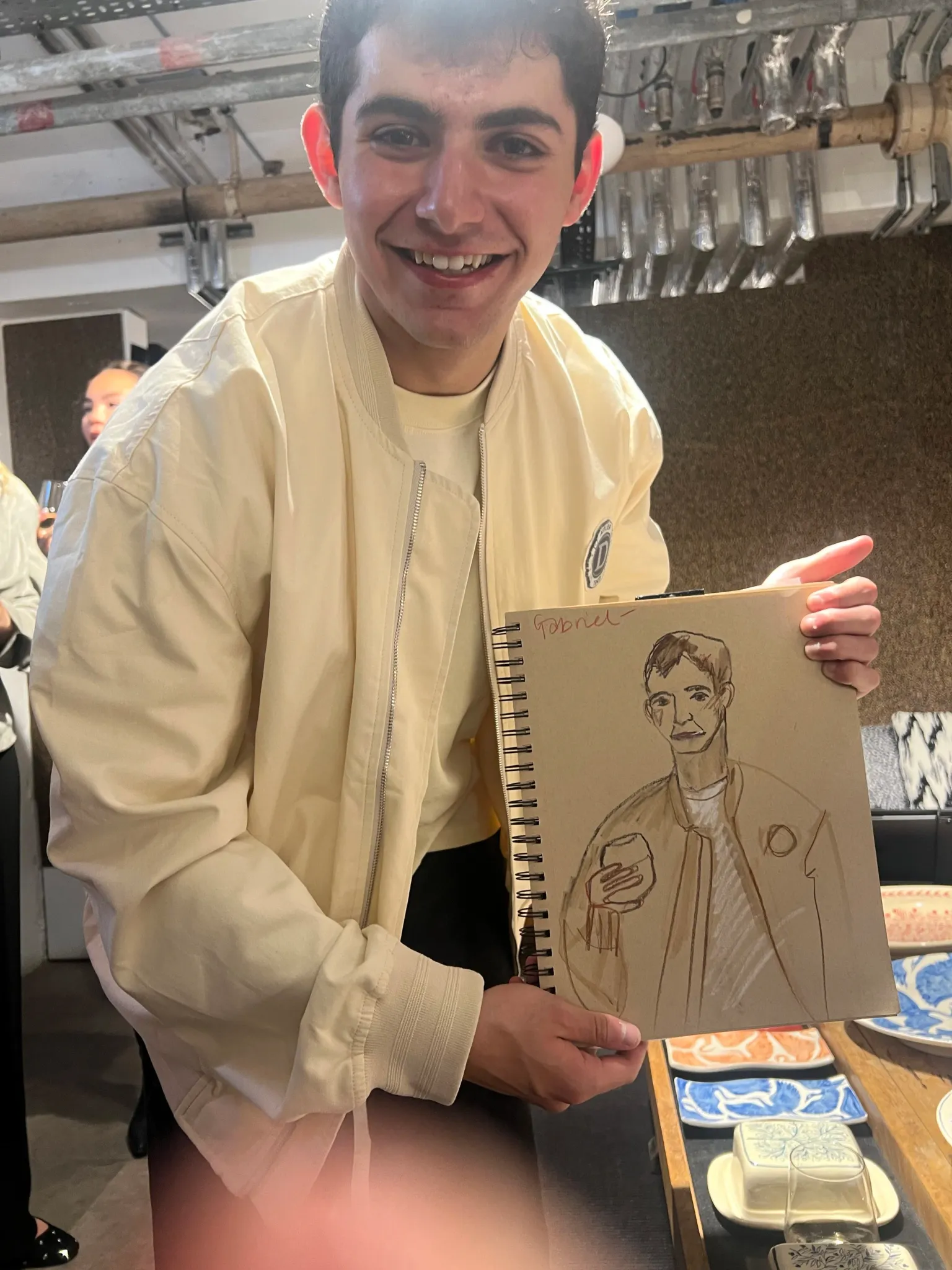 Smiling man holding a sketch of himself.