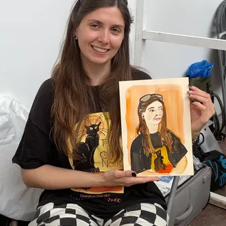 A guest at a live event holds the ink portrait Tracey Smith has drawn of her.